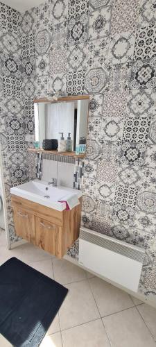bagno con lavandino e specchio a parete di CHALET ANTLANA maison chaleureuse a Signy-lʼAbbaye
