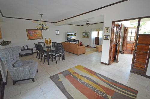 a living room with a dining table and chairs at Villa Fernando, Ocho Rios Jamaica in Mammee Bay