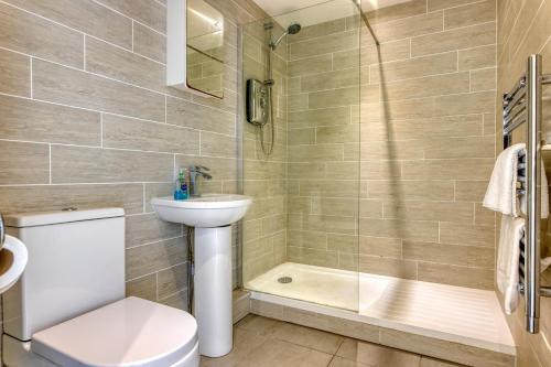 uma casa de banho com um WC, um chuveiro e um lavatório. em Granville Marina: Stunning sea view property with easy parking em Ramsgate
