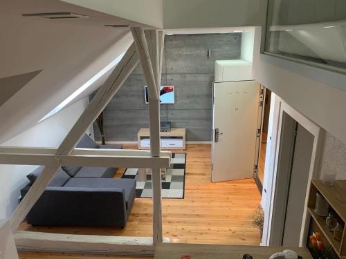 a room with a staircase with a couch and a refrigerator at Loft Osijek in Osijek
