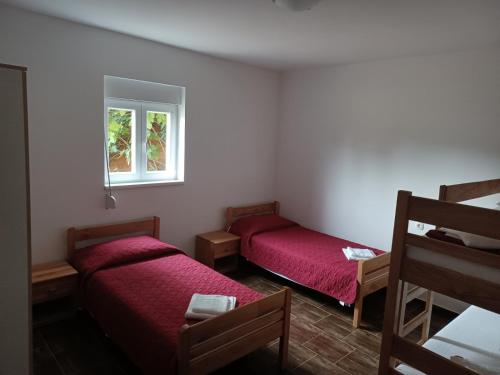 a room with two beds and a window at Apartman Milanko in Muškovci
