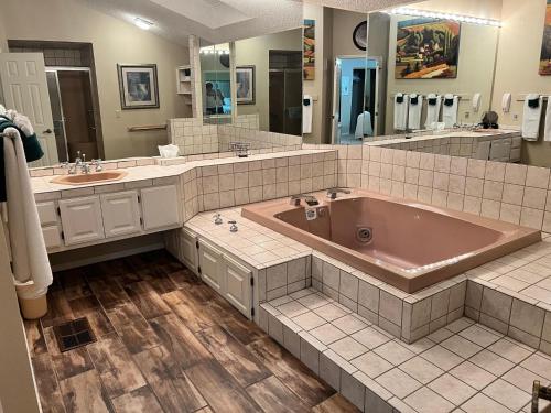 uma grande casa de banho com uma grande banheira e 2 lavatórios em Trailside Vacation Home 9 em Bella Vista