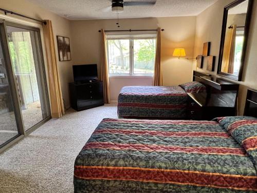 um quarto de hotel com duas camas e uma televisão em Trailside Vacation Home 9 em Bella Vista