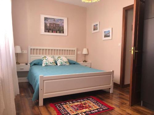a bedroom with a bed with blue sheets and pillows at CASA LUPITA in Cudillero