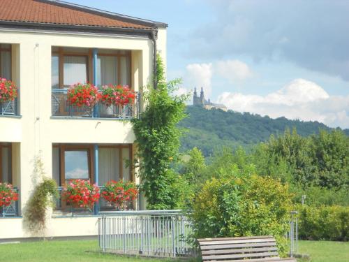 a building with flowers on the balconies and a castle at Best Western Plus Kurhotel an der Obermaintherme in Bad Staffelstein