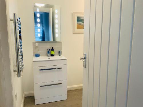 biała łazienka z umywalką i lustrem w obiekcie Beautiful 1-Bed Riversi Cottage Located in Malpas w mieście Truro