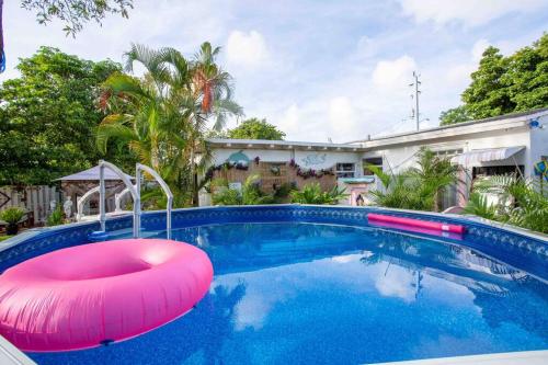 una piscina con galleggiante rosa di fronte a una casa di Pool King Sweet Karma on Water Best Location Beaches,Restaurants,Hard Rock Casino a Hallandale Beach