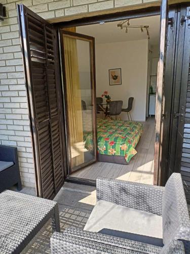 a screened porch with a bed and a glass door at DUŠICA APARTMANI in Jagodina