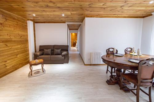 sala de estar con mesa y sofá en La Casona 1930, en Mazaricos