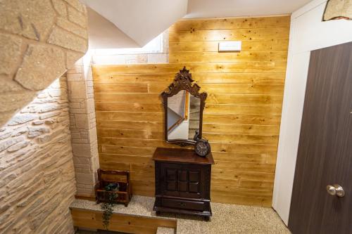 a mirror on a wooden wall in a hallway at La Casona 1930 in Mazaricos