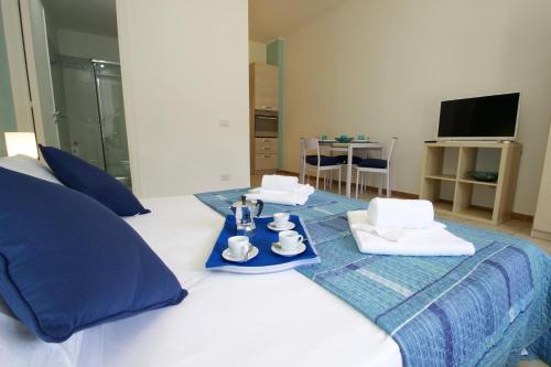 Una habitación de hotel con una cama con una bandeja de comida. en Taormina Studio Apartments, en Giardini Naxos