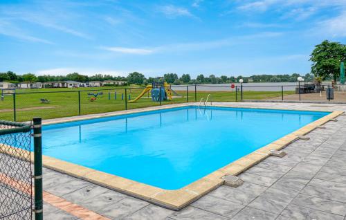 een zwembad in een park met een speeltuin bij Luxe chalet direct aan het water met strand in Lith