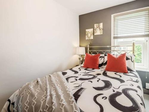 a bedroom with a black and white bed with red pillows at Stylish Uphill Townhouse in Lincoln