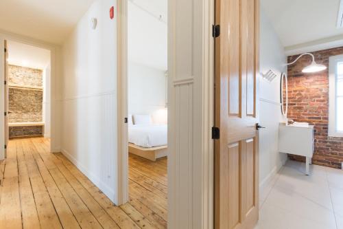 einen Flur mit Ziegelwand und ein Schlafzimmer in der Unterkunft La Maison des Lofts - Par les Lofts Vieux-Quebec in Québec