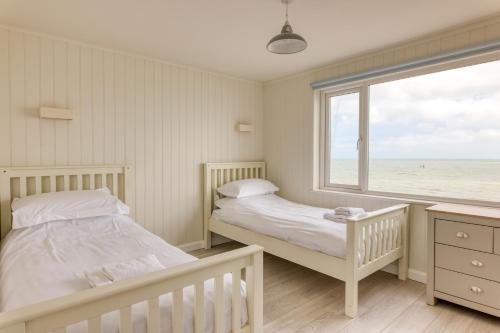 twee bedden in een kamer met uitzicht op de oceaan bij Granville Marina: Stunning sea view property with easy parking in Ramsgate