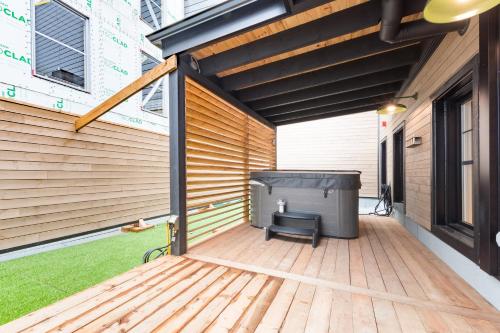 a patio with a hot tub on a wooden deck at La Maison des Lofts - Par les Lofts Vieux-Quebec in Quebec City