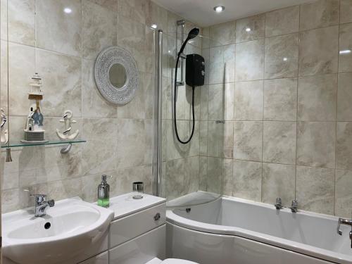 a bathroom with a sink and a tub and a shower at Craven Cottage in Northallerton