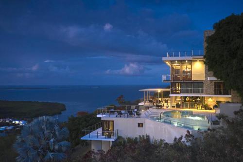 a house with a swimming pool at night at Happy Days Villa A in Fajardo