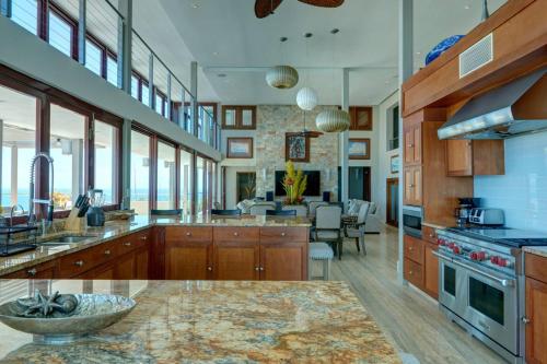 a large kitchen with wooden cabinets and a living room at Happy Days Villa A in Fajardo
