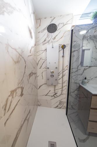 a shower in a bathroom with a marble wall at La Casona 1930 in Mazaricos