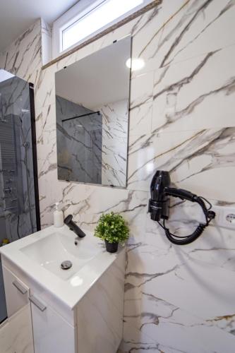 a white bathroom with a sink and a mirror at La Casona 1930 in Mazaricos