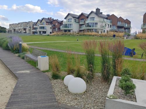プツクにあるApartament DELFINのベンチ付き公園、一部の家屋と畑