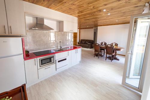 a kitchen with white cabinets and a dining room with a table at La Casona 1930 in Mazaricos