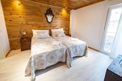 a bedroom with a bed and a wooden wall at La Casona 1930 in Mazaricos