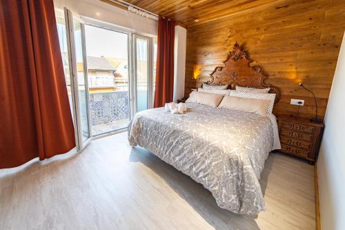 a bedroom with a large bed and a large window at La Casona 1930 in Mazaricos