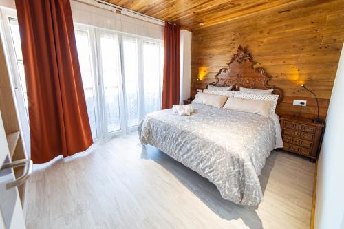 a bedroom with a bed with a wooden wall at La Casona 1930 in Mazaricos