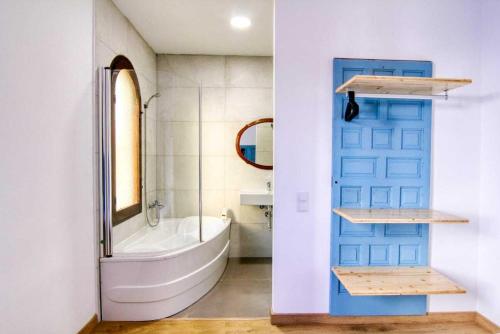 a bathroom with a blue door and a bath tub at Villa Carlos in Vinarós