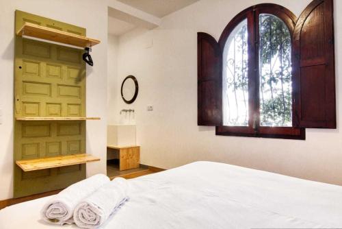 1 dormitorio con 1 cama y ventana con toallas en Villa Carlos en Vinarós