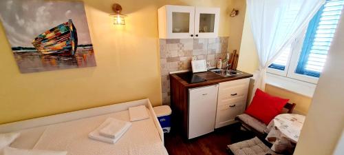 a small room with a bed and a sink at APARTMANI CENTAR VODICE in Vodice