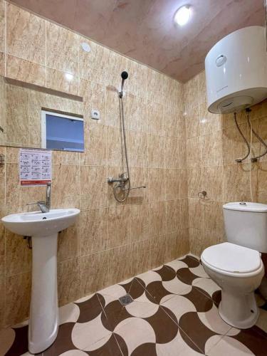 a bathroom with a toilet and a sink and a shower at Del Mar in Ureki