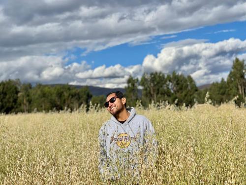 a man standing in a field of tall grass at CasaHotel Laguna Jauja Airport in Jauja