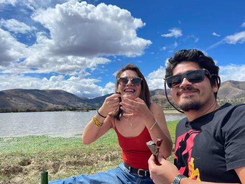 a man and a woman sitting next to a lake at CasaHotel Laguna Jauja Airport in Jauja