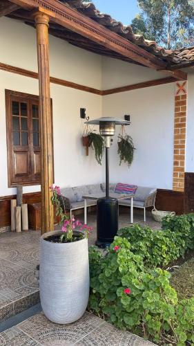 a patio with a table and a bench and flowers at CasaHotel Laguna Jauja Airport in Jauja