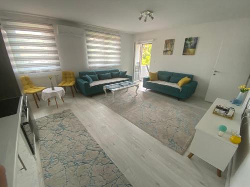 ein Wohnzimmer mit zwei blauen Sofas und einem Tisch in der Unterkunft Sunset Delux Apartment in Visoko