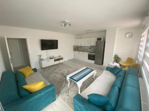 een woonkamer met een blauwe bank en gele kussens bij Sunset Delux Apartment in Visoko