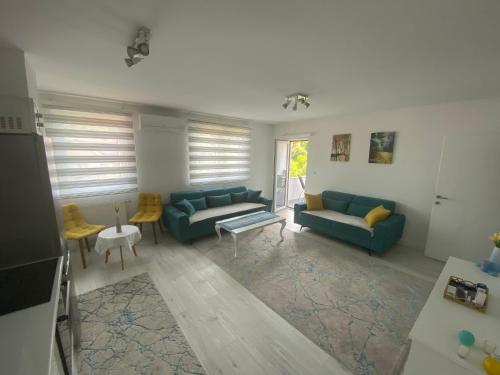 een woonkamer met twee blauwe banken en een tafel bij Sunset Delux Apartment in Visoko