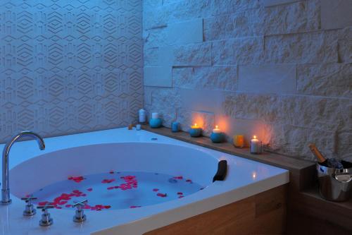 un baño con una bañera con flores rojas. en BluOtranto, en Otranto