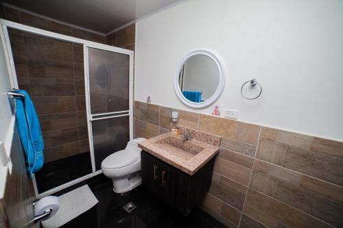a bathroom with a toilet and a sink and a mirror at APARTAMENTO FAMILIAR EN HOTEL in San Andrés