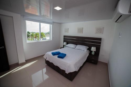a bedroom with a large bed and a window at APARTAMENTO FAMILIAR EN HOTEL in San Andrés