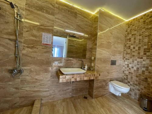 a bathroom with a sink and a toilet and a shower at Del Mar in Ureki