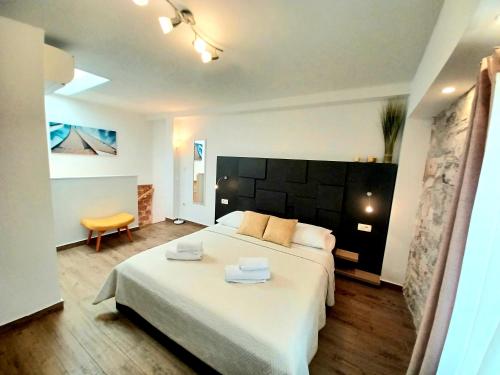 a bedroom with a large bed with two towels on it at Studio Apartmani Pomalo/ Take It Easy in Split