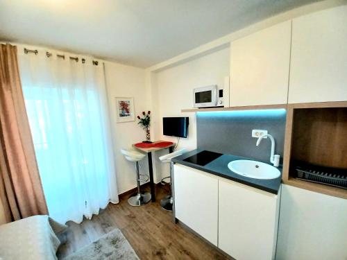 a small bathroom with a sink and a microwave at Studio Apartmani Pomalo/ Take It Easy in Split