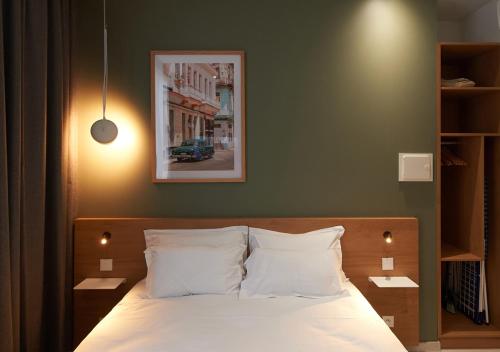 a bedroom with a bed with a picture on the wall at Corner-Set Cholet Centre in Cholet