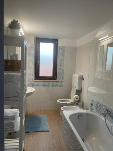 a bathroom with a tub and a toilet and a sink at Casa Drema - Villa al mare con terrazza in Pescara