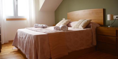 a bedroom with a bed with two towels on it at Apartamentos Gallaecia in Val do Dubra