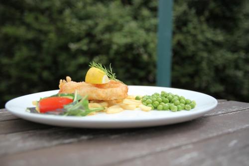 a plate of food with fish and vegetables on a table at Fernhill Hotel in Lyme Regis